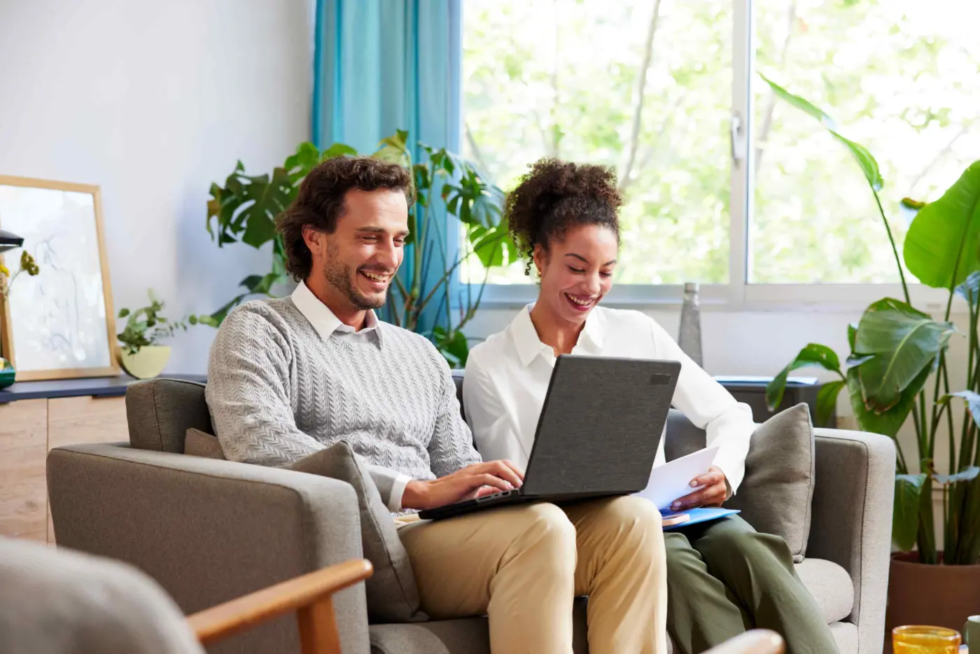 A couple happily reviewing their finances through the Community Choice Credit Union account
