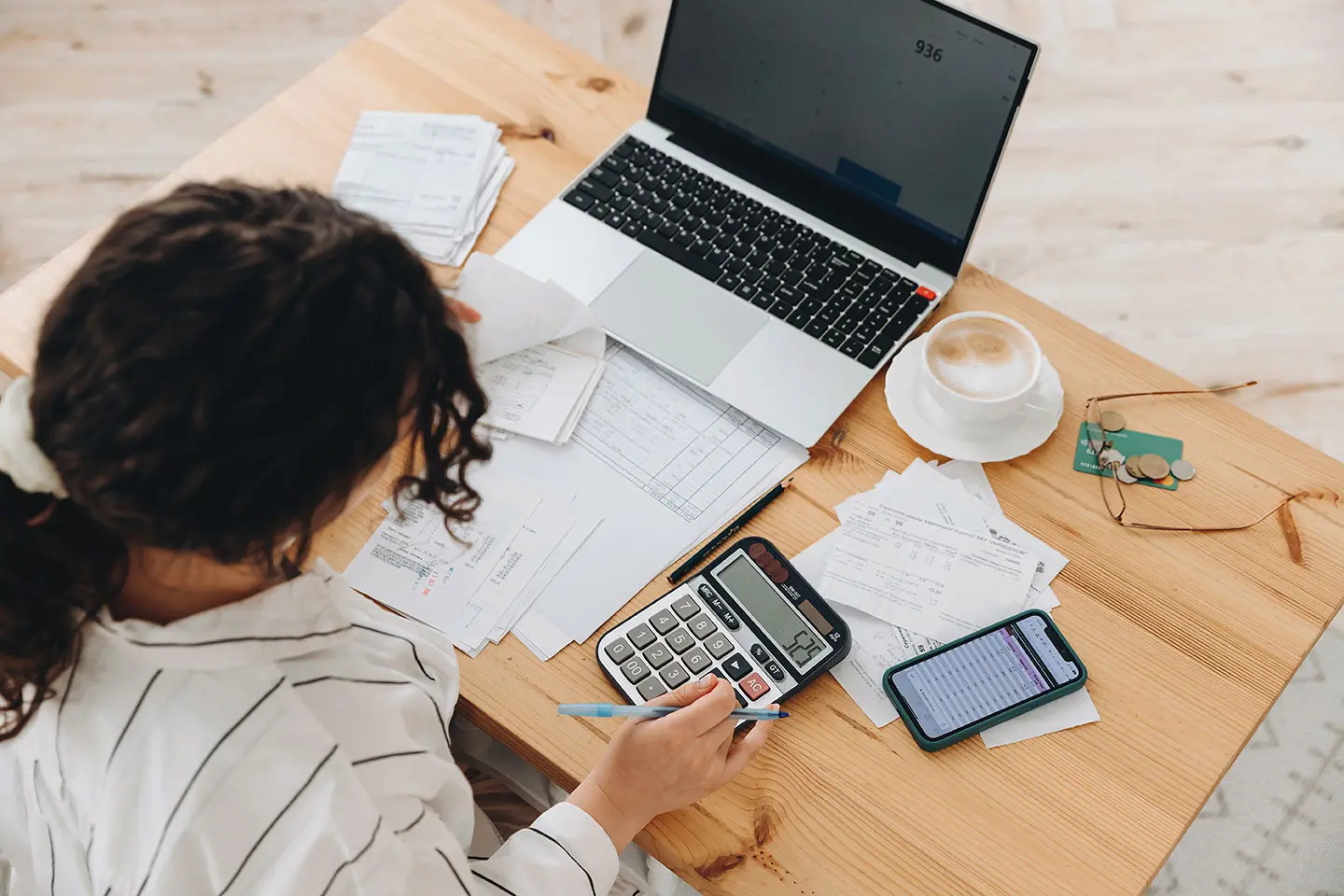 woman using calculator near laptop