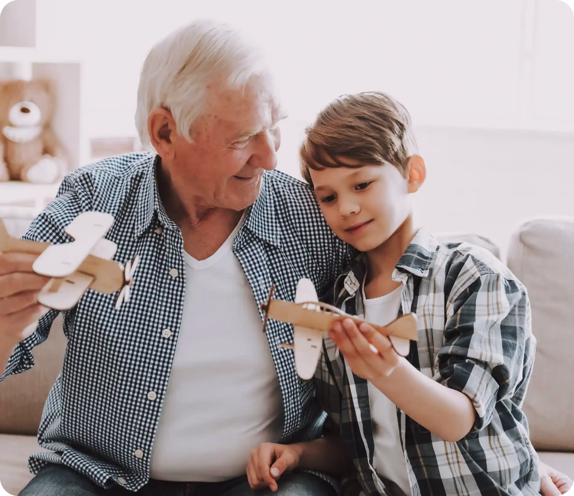 A grandfather and grandson playing with airplane toys
