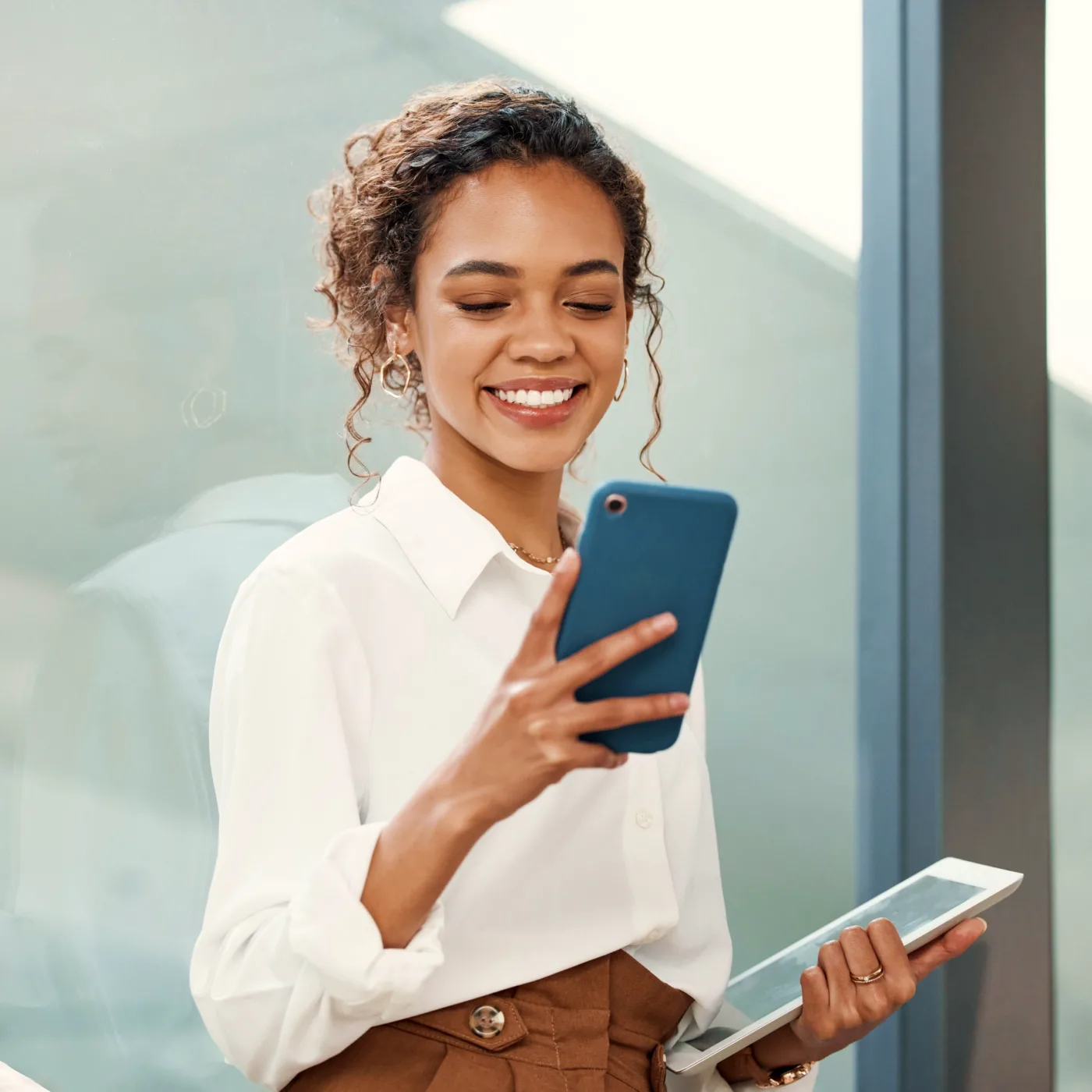 A business woman checks her phone to see her ModernFi balance through Community Choice