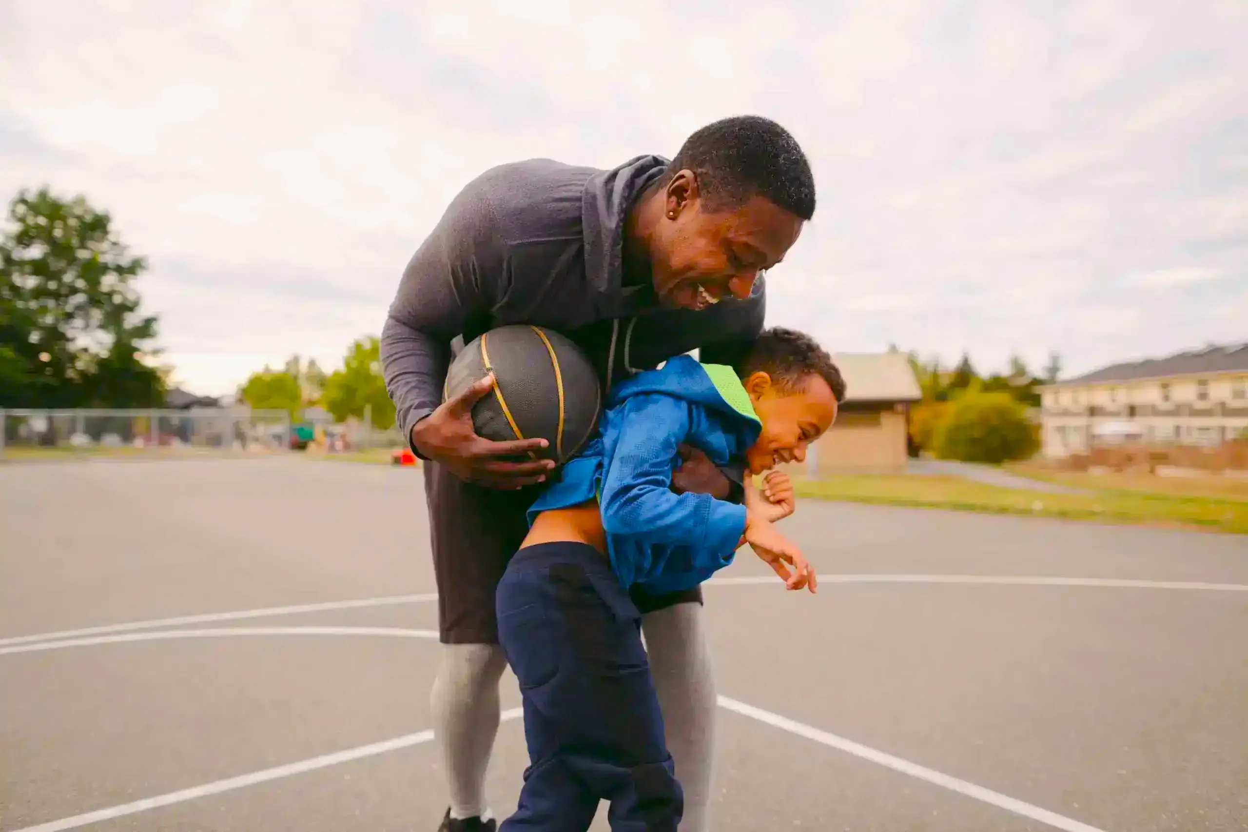 A father and son have fun playing basketball after opening a youth account at Community Choice Credit Union