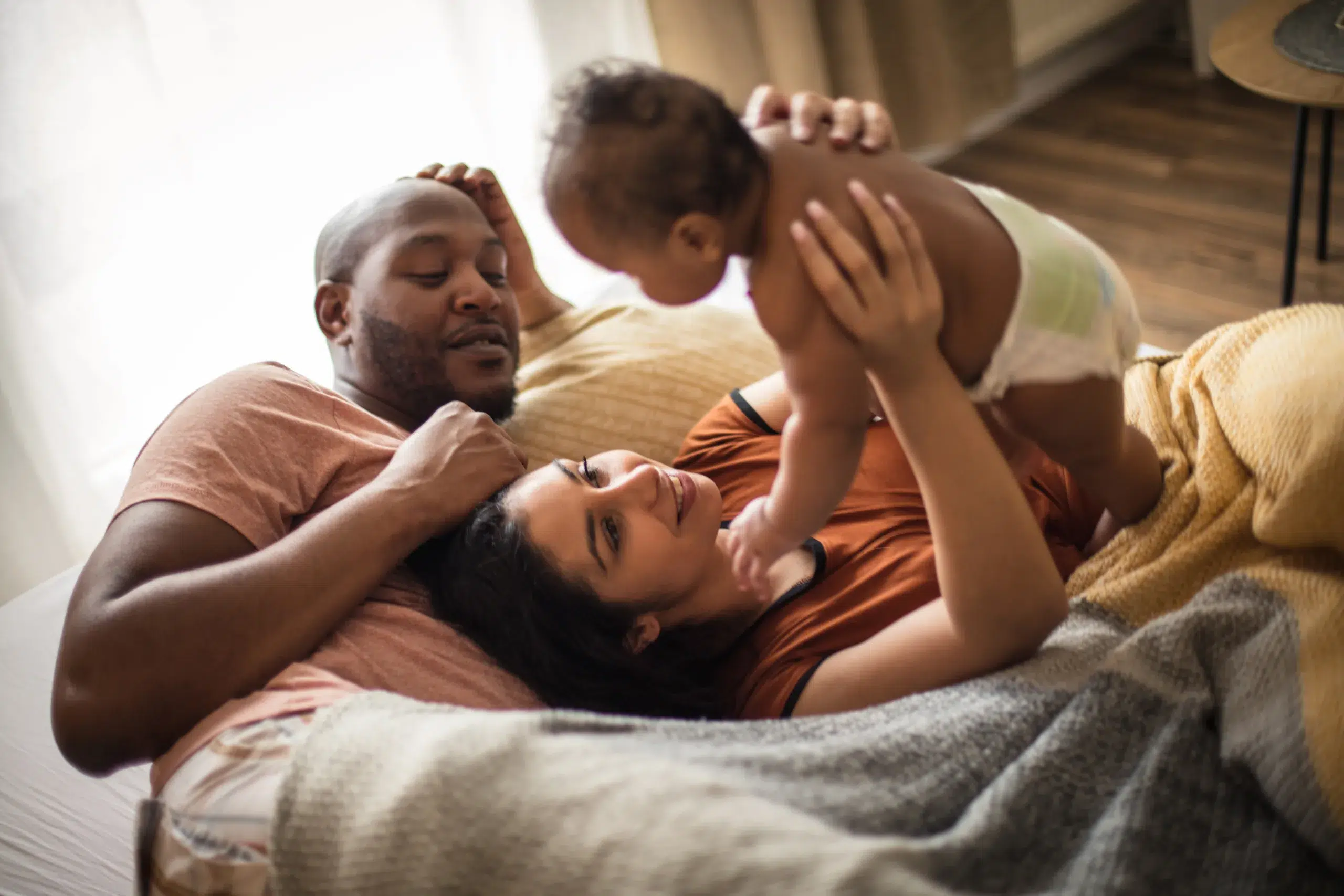Parents with daughter on bed. Community Choice Credit Union