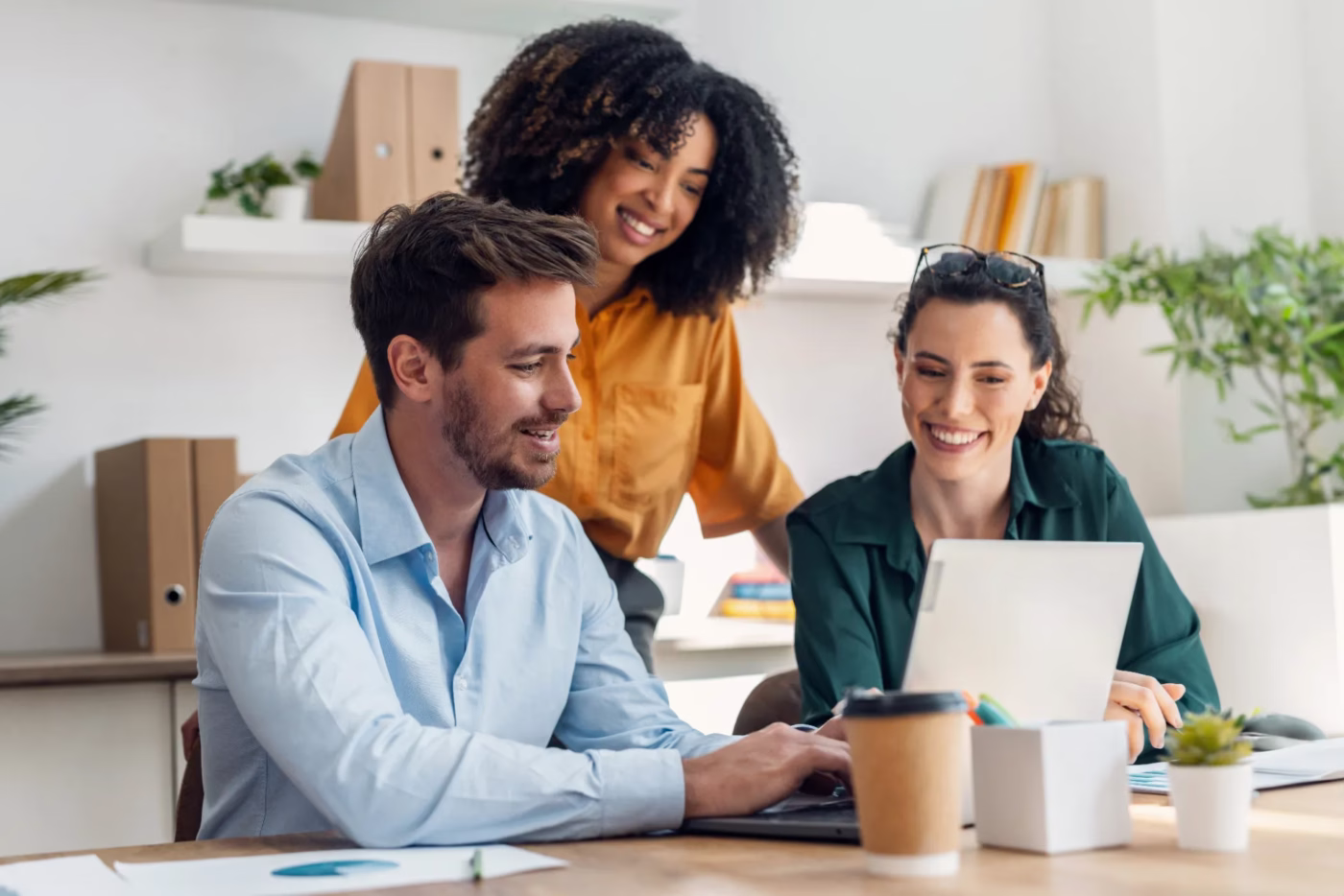Three business colleagues working together off of one laptop