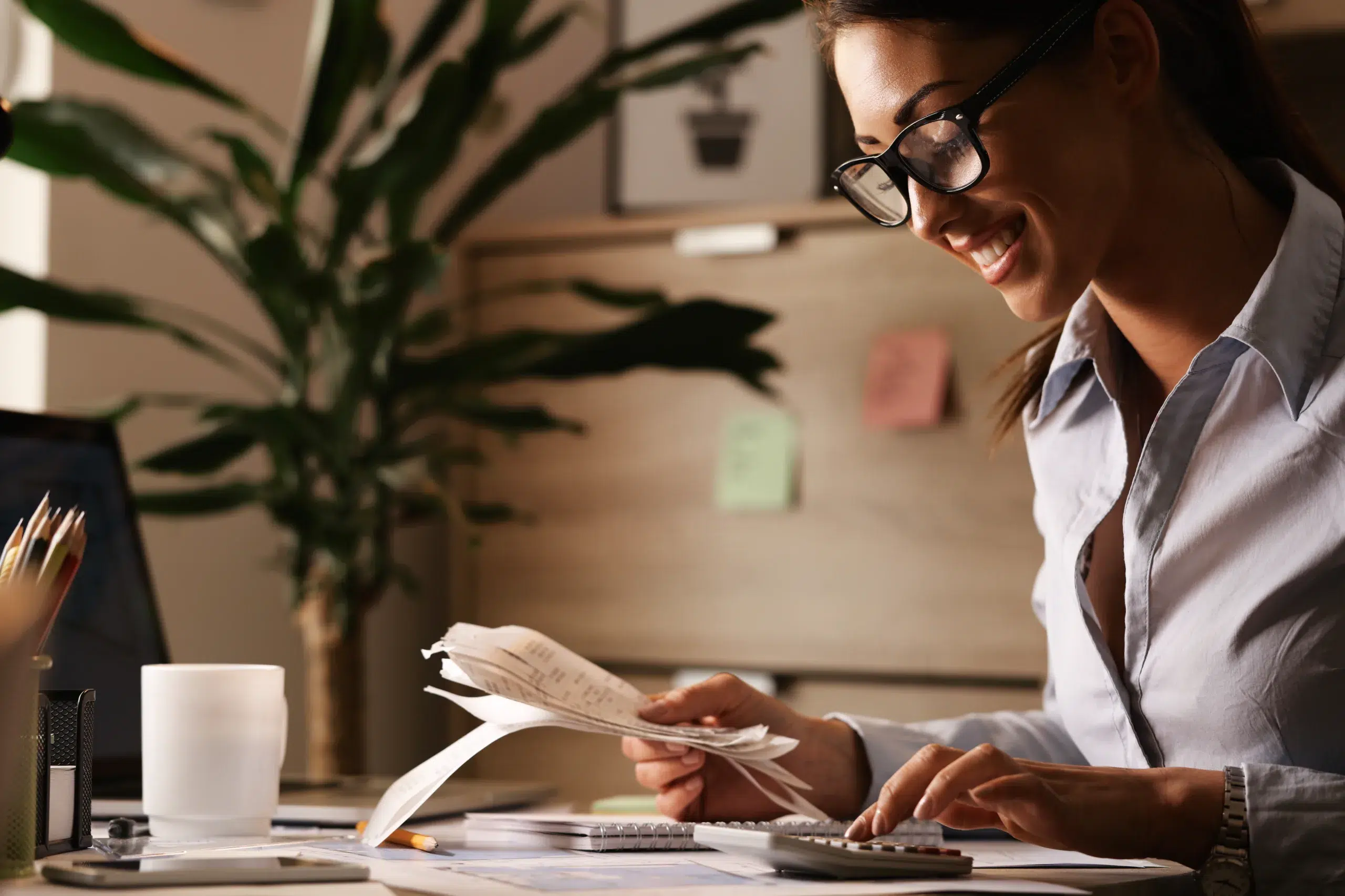 Young happy business accountant calculating financial bills while working in her office. Community Choice Credit Union