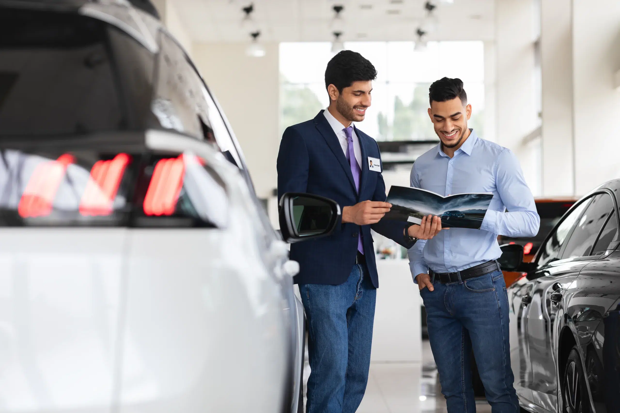 A man at a car dealer buying a car and comparing an auto loan with Community Choice Credit Union