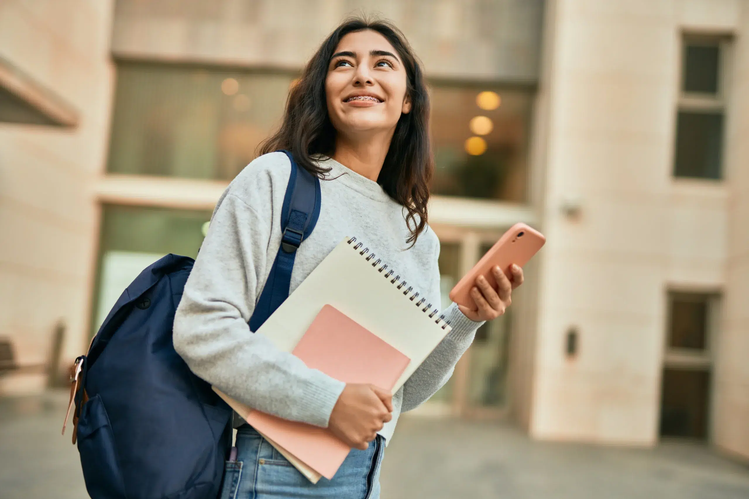 Young student girl smiling happy with her backpack at college.